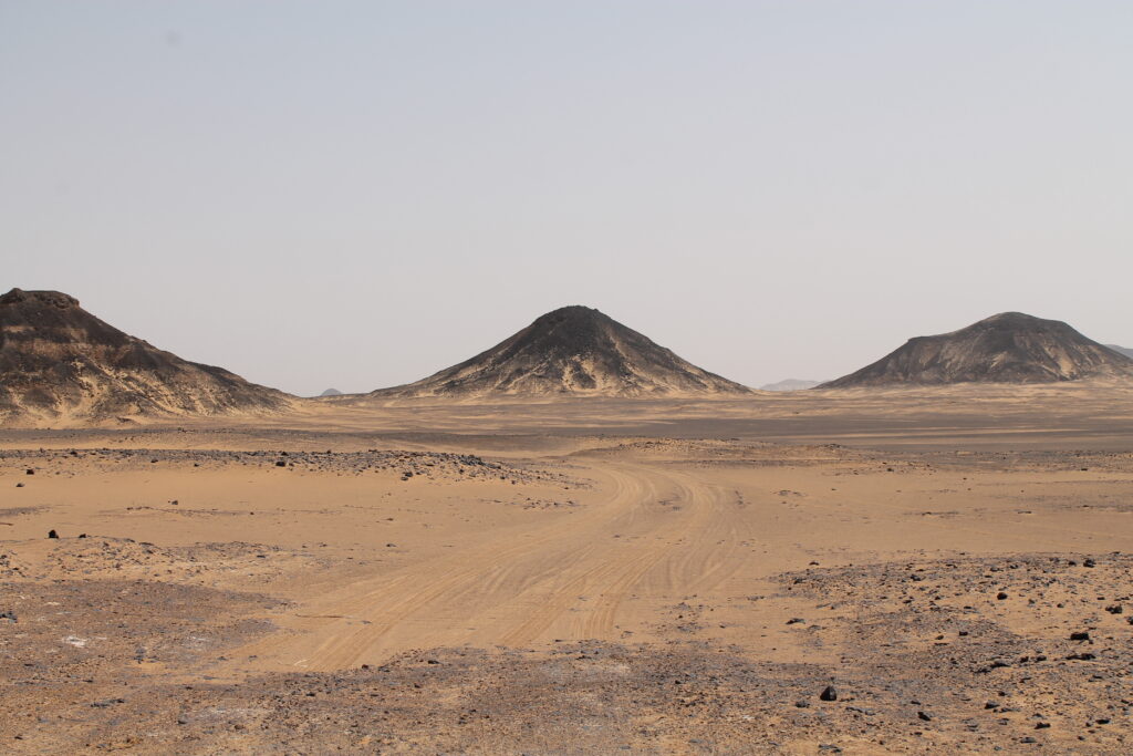Black conical mountains in the Black Desert, Egypt.