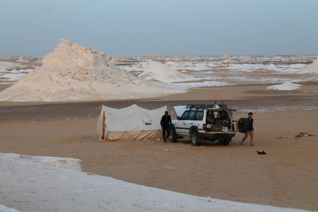Jeep parked beside tent and camp site on the White Desert Tour.
