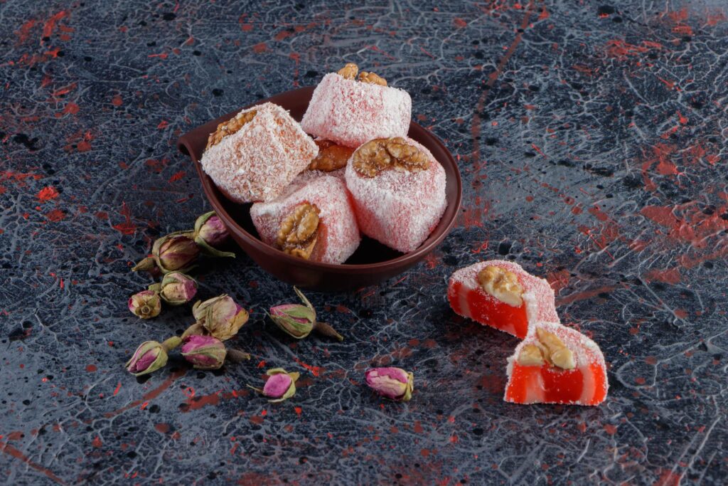 Small bowl of rose flavoured Turkish delight with dried roses.