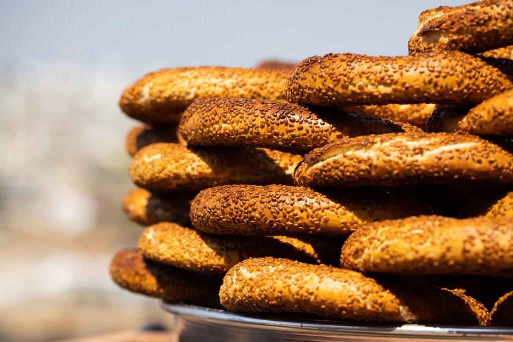Stacked pile of simit bagels on a silver platter.
